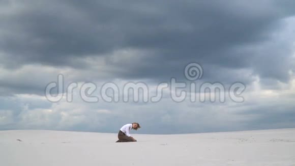 快乐的女孩坐在沙滩上视频的预览图