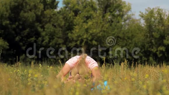 阳光明媚的夏日一个可爱的成年女孩在公园户外做瑜伽视频的预览图