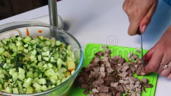 带有蔬菜和蛋黄酱的俄罗斯肉沙拉一个女人切肉做沙拉视频的预览图