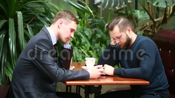 两个商人在咖啡店讨论视频的预览图