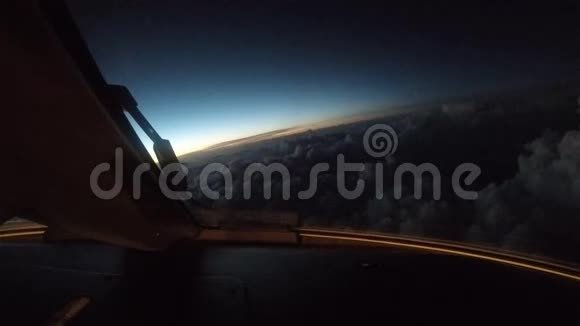日落时飞机在云层上方飞行从驾驶舱看到的景色视频的预览图