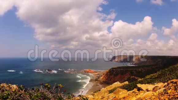 带着岩石沙子和快速移动的波浪和云的海滩的延时镜头视频的预览图