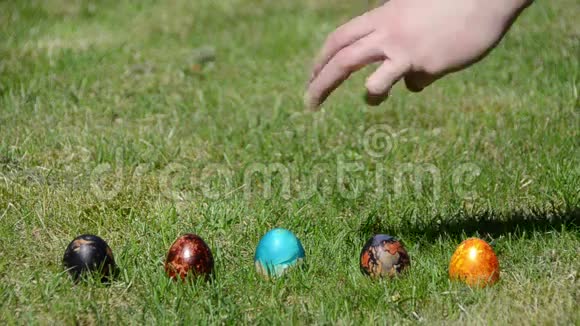 家庭复活节游戏在草地上涂上五颜六色的鸡蛋视频的预览图