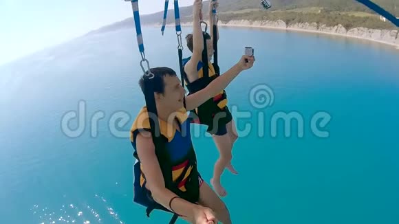 滑翔伞和滑翔伞的生活方式人类和男孩是海洋乘降落伞飞越海洋极限运动视频的预览图