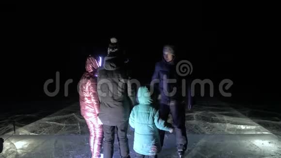 家人是滑冰之夜女孩和男孩在大自然中骑花样冰鞋母亲父亲女儿和儿子视频的预览图