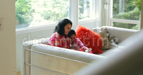 母亲和女儿在客厅看书视频的预览图