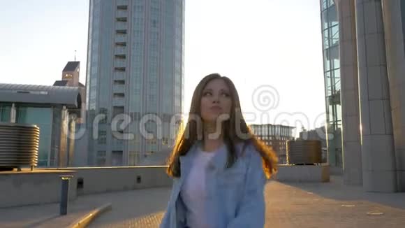一位留着长发的褐发女子在夕阳的映衬下翩翩起舞视频的预览图