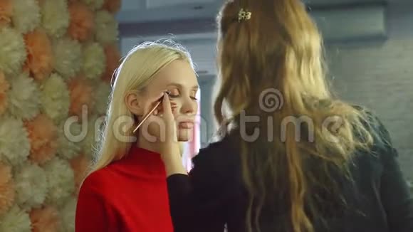 年轻女子在美容院给模特化妆视频的预览图