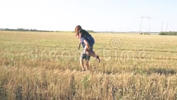 燕麦地背景下的夏季大自然中的年轻情侣视频的预览图