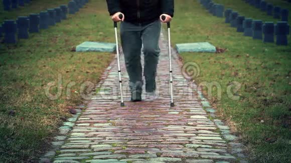 残疾退伍军人拄着拐杖在墓地散步视频的预览图