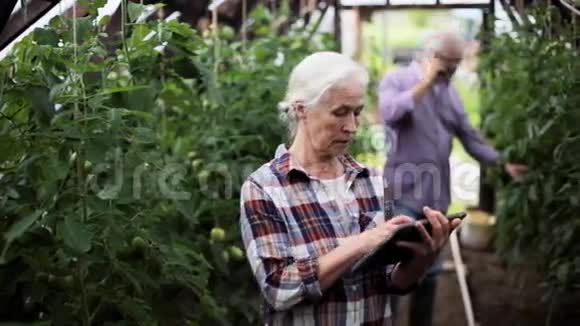 农场温室里有平板电脑的老妇人视频的预览图