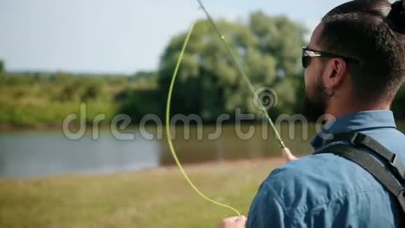 渔夫钓鱼拿着鱼竿钓鱼饵旋转卷轴视频的预览图