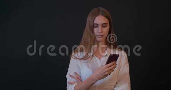 一个使用智能手机的漂亮年轻女人视频的预览图