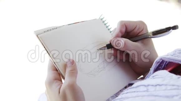 戴墨镜的女孩在笔记本上画素描视频的预览图