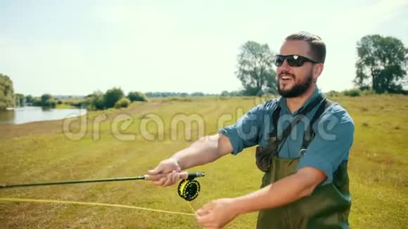 渔夫钓鱼拿着鱼竿钓鱼饵旋转卷轴视频的预览图