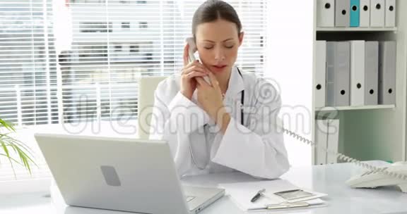 医生在桌旁打电话视频的预览图