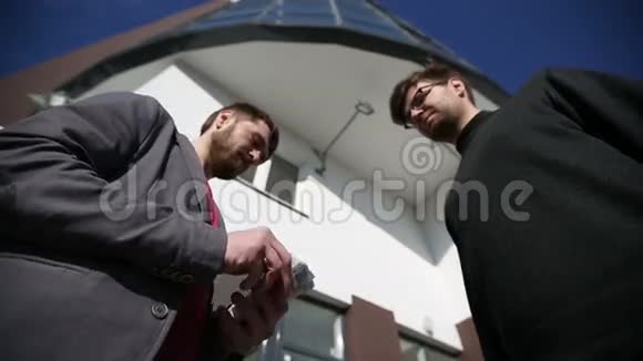 男人互相递钱欧元钞票握手视频的预览图