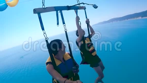 滑翔伞和滑翔伞的生活方式男人和男孩正在海上乘着一个降落伞飞行极限运动视频的预览图