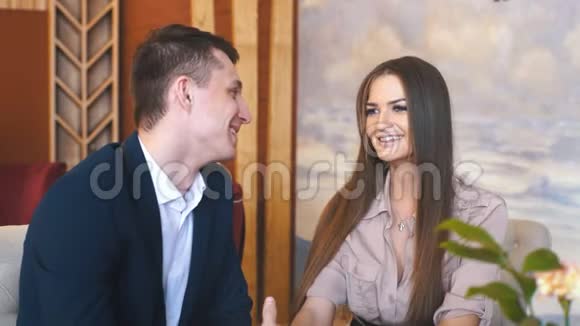 在咖啡馆里调情一对美丽的情侣坐在咖啡馆里享受咖啡和交谈视频的预览图