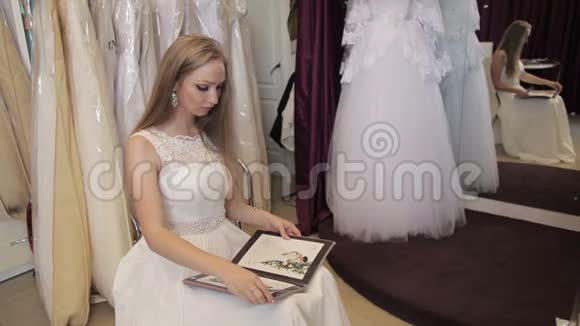 女孩在婚礼沙龙里选择婚纱视频的预览图