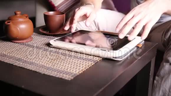年轻的商人使用平板电脑进行网上购物男人在电脑平板电脑上工作在咖啡馆喝茶视频的预览图