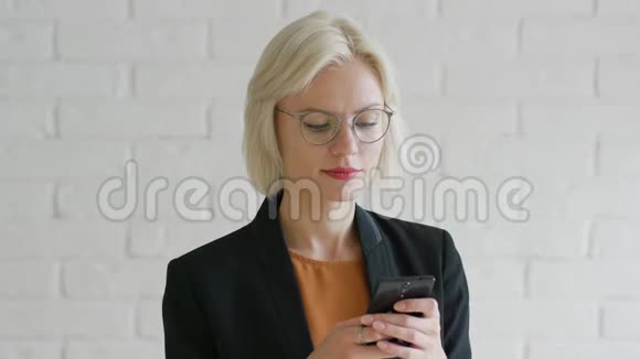 优雅的女商人浏览智能手机视频的预览图
