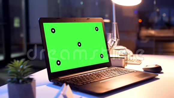 夜间办公室配有绿色屏幕的笔记本电脑视频的预览图