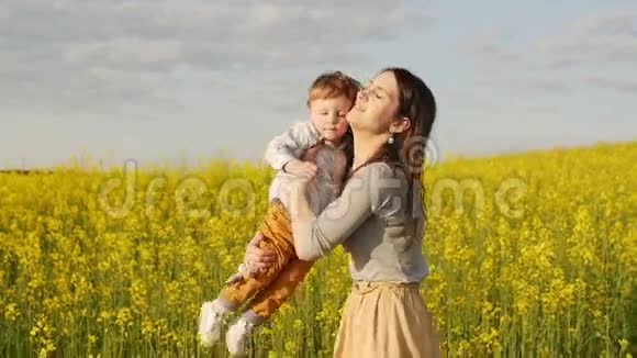 日落时分母亲抱着她的儿子在田野里慢节奏视频的预览图