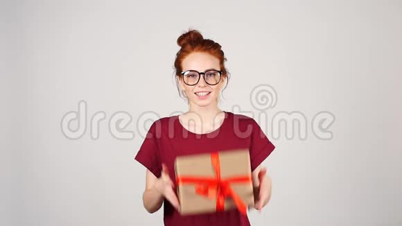美丽的微笑女孩手中拿着礼品盒的肖像视频的预览图