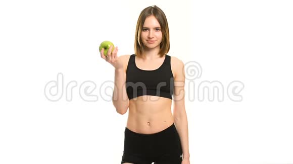 苗条健康的年轻女子抱着一个苹果被隔离在白色背景上减肥和饮食观念视频的预览图