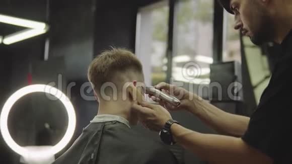 男式理发用电动剃须刀理发师在理发店为顾客理发男子视频的预览图