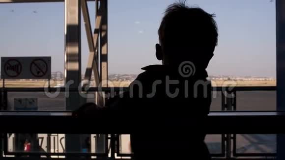 在机场透过窗户看的小男孩视频的预览图