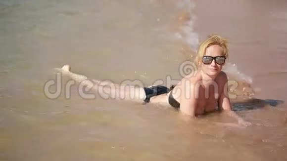 在沙滩上躺在水里的女孩暑假休息视频的预览图