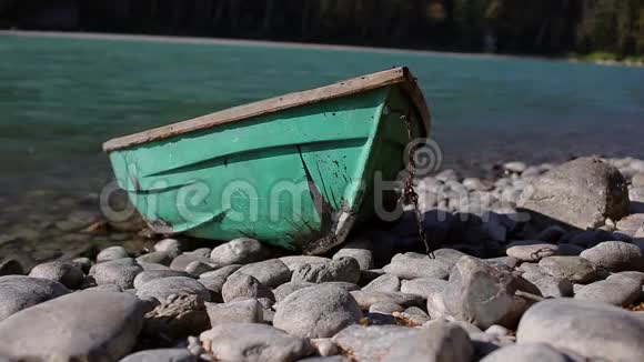 古老的绿色木船在一条山河的岸边视频的预览图