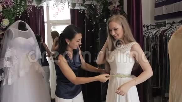 女孩在婚礼沙龙里选择婚纱视频的预览图