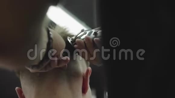 男式理发用电动剃须刀把头发修剪整齐的发型收起来理发师为理发店的顾客理发视频的预览图