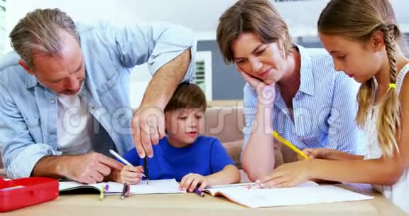 父亲和母亲帮助孩子做家庭作业视频的预览图