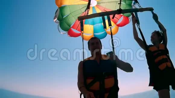 滑翔伞和滑翔伞的生活方式人类和男孩的海洋正在用降落伞飞越海洋极限运动视频的预览图