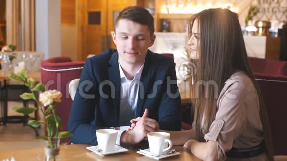 在咖啡馆里调情一对美丽的情侣坐在咖啡馆里享受咖啡和交谈视频的预览图