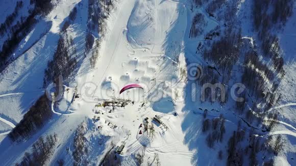 滑翔伞在滑雪场的山上飞过视频的预览图