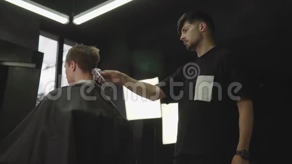 男式理发用电动剃须刀理发师在理发店为顾客理发男子视频的预览图