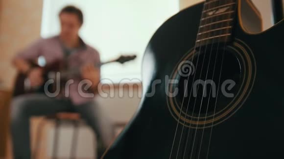 年轻有魅力的音乐家用吉他和戏剧作曲还有前景的其他乐器视频的预览图