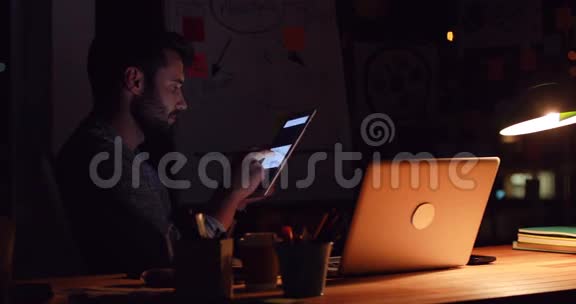 业余商人晚上用平板电脑视频的预览图