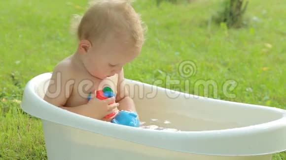 可爱的幼儿在花园里洗澡视频的预览图