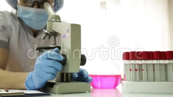 女性医学研究人员在实验室条件下使用显微镜和试管进行调查和采集视频的预览图