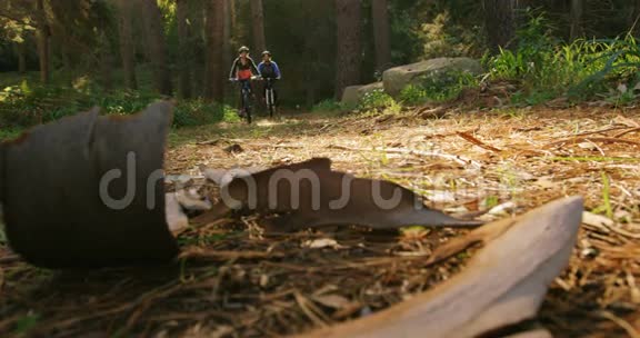 阳光明媚的一天一对山地自行车夫妇在森林里骑马视频的预览图