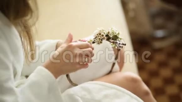 穿着白色酒店礼服的新娘编织着花环视频的预览图