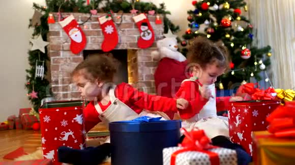 两个戴着圣诞老人帽子的小女孩坐在地上视频的预览图