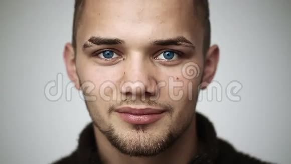一个蓝眼睛的年轻人微笑着牙齿上戴着牙套眨眼视频的预览图