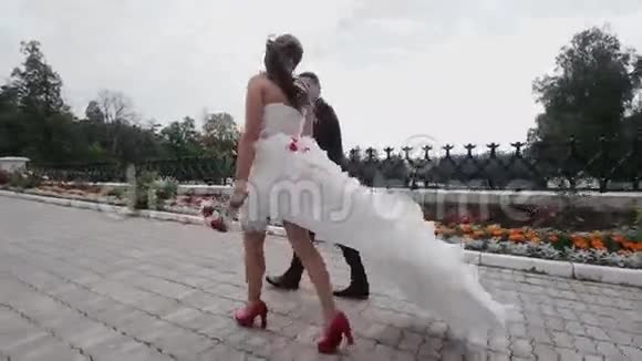 新婚夫妇牵着手在公园散步视频的预览图